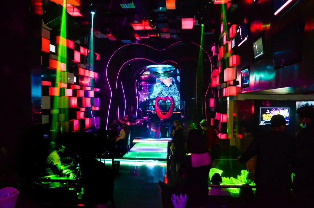 Green lasers cutting across the main room and heart installation at Chameleon Club Dubai