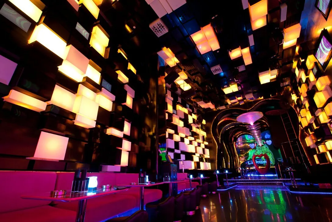 Main room at Chameleon Club Dubai lit in amber and pink by kinetic LED cube walls